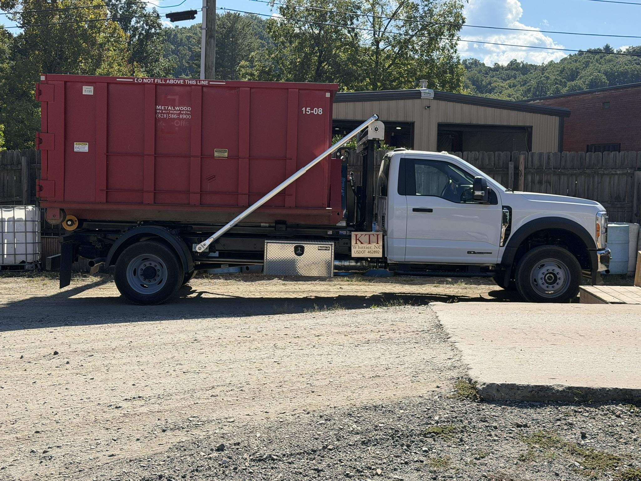 A Metalwood Recycling roll-off container loaded on the hook truck, ready to drop